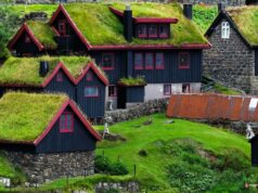 Faroe Adaları'nda yeşil çim çatılı geleneksel evler ve dramatik doğal manzara